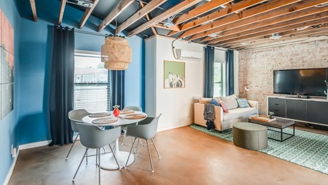 A modern living room with a dining table and chairs.